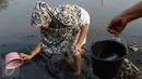 Seorang ibu bersama anaknya mencari ikan dan udang di bantaran Kanal Banjir Timur, Cipinang Muara, Jakarta, Selasa (16/5). Kegiatan itu dilakukan sejumlah ibu bersama anak-anaknya untuk mengisi masa libur sekolah. (Liputan6.com/Immanuel Antonius)