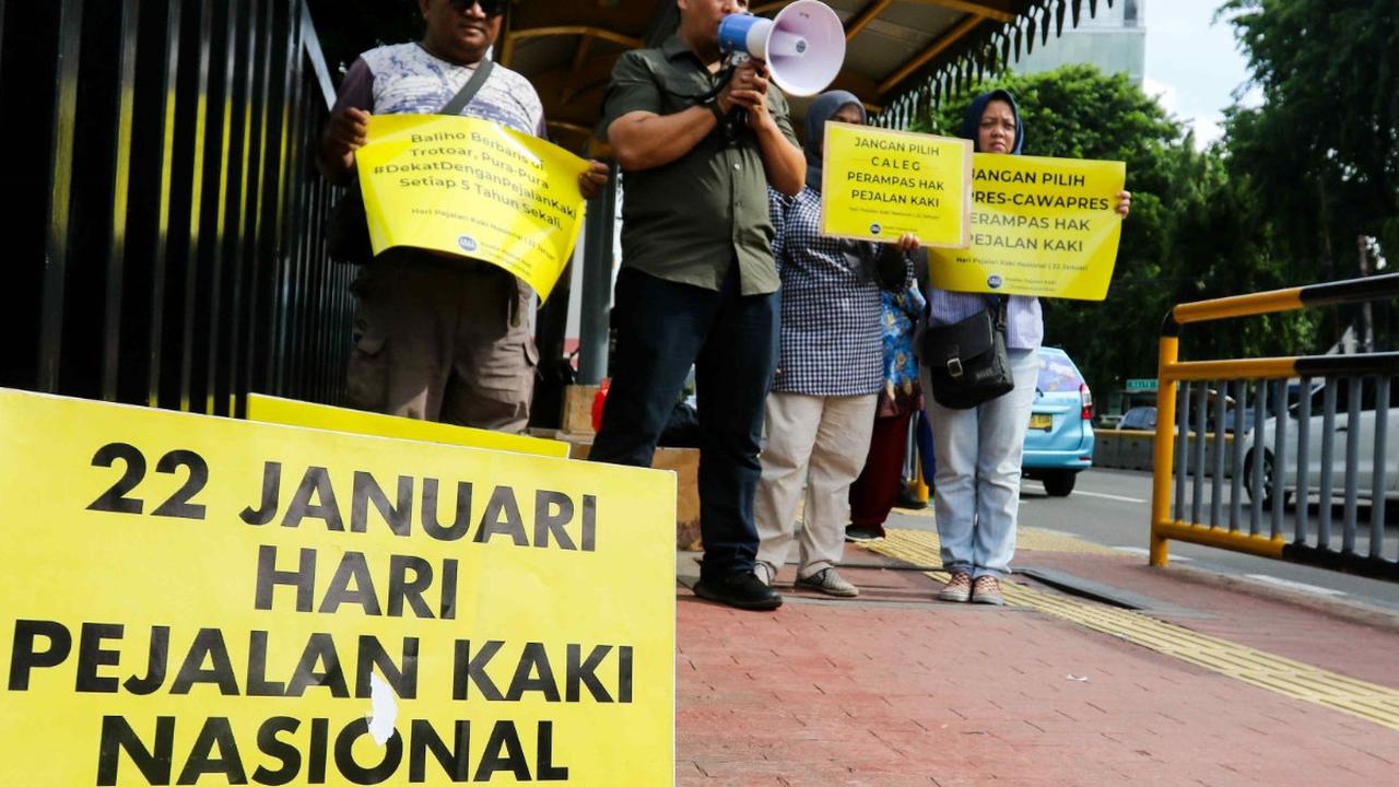 Aktivis dari Koalisi Pejalan Kaki menggelar aksi di kawasan Halte Tugu Tani, Jakarta, Senin (22/1/2024).<br>Mereka beraksi membawa dan membentangkan poster berwarna kuning dan berorasi di kawasan tersebut.<br>( Foto Liputan6.com / Herman Zakharia )