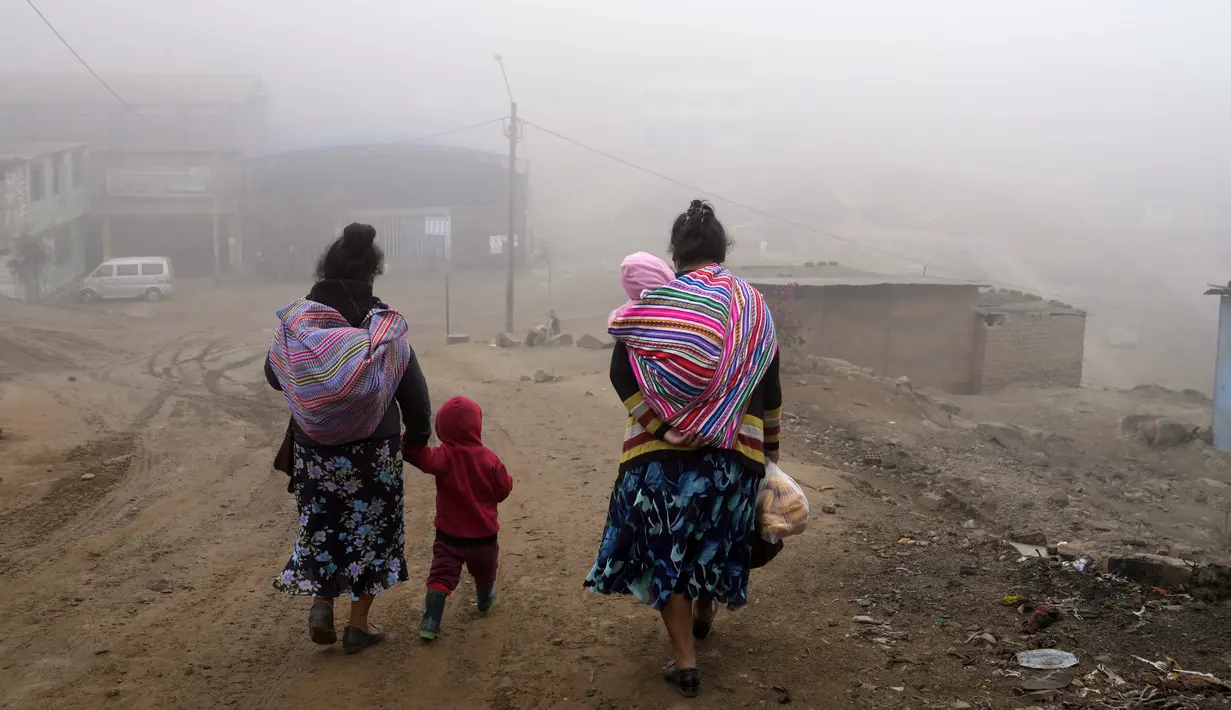 <p>Warga berjalan melalui kabut dingin dan tebal pada hari resmi pertama musim dingin, di lingkungan Ticlio Chico di pinggiran Lima, Peru, Selasa (21/6/2022). Suhu di ibu kota adalah yang terendah dalam 25 tahun, menurut National Layanan Meteorologi dan Hidrologi Peru. (AP Photo/Martin Mejia)</p>