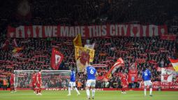 Para pendukung Liverpool membentangkan spanduk dan mengangkat syal dalam laga lanjutan Liga Inggris 2024/2025 melawan Everton di Anfield, Liverpool, Inggris, Rabu (02/04/2025) waktu setempat. (AP Photo/Ian Hodgson)