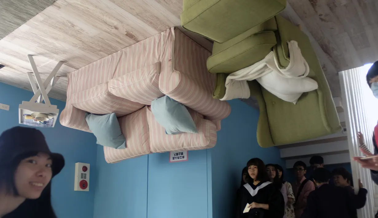 Wisatawan berkeliling di bagian dalam rumah terbalik di Huashan Creative Park, Taipei, Taiwan, Selasa (8/3/2016). Bangunan unik ini berdiri terbalik dengan luas sekitar 300-an meter persegi dan dibuka untuk umum hingga 22 Juli mendatang. (SAM YEH/AFP)