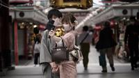 Pengunjung dengan masker pelindung untuk membantu mencegah penyebaran virus corona berfoto selfie di pusat perbelanjaan di distrik Asakusa di Tokyo, Selasa (29/9/2020). kota Jepang mengonfirmasi lebih dari 200 kasus virus corona pada hari Selasa. (AP Photo/Eugene Hoshiko)