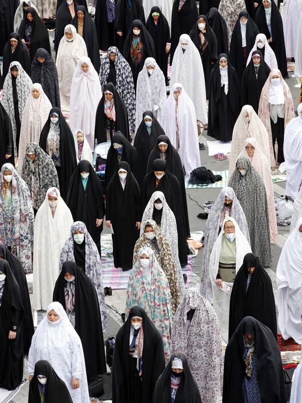 Perempuan Muslim menjaga jarak satu sama lain sebagai langkah mencegah pandemi Covid-19 saat berkumpul untuk menghadiri salat Idul Fitri di ibu kota Iran, Teheran, pada 24 Mei 2020. (Photo by - / AFP)