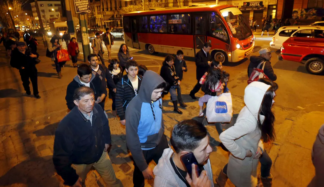 Sejumlah orang berusaha menyelamatkan diri usai gempa 8,3 SR yang mengguncang  di Santiago, Chile, Rabu (16/9).  Menurut laporan dari otoritas setempat, gempa itu berpotensi memicu tsunami yang akan melanda Chile dan Peru.  (REUTERS/Rodrigo Garrido)