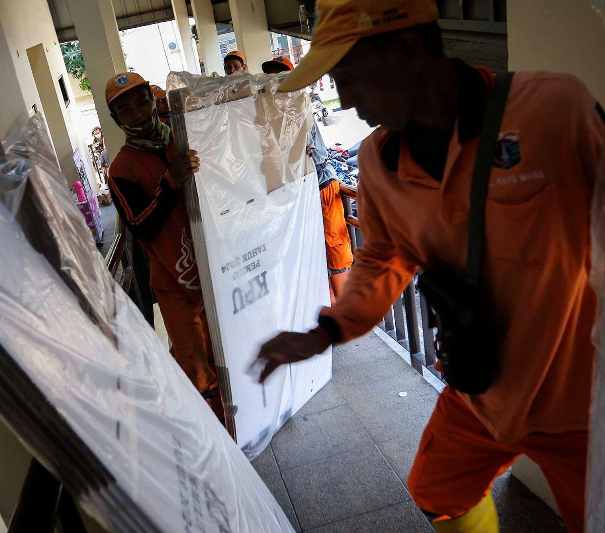 Petugas Prasarana dan Sarana Umum (PPSU) membantu memindahkan bilik dan kotak suara Pemilu 2024 ke GOR Matraman, Jakarta Timur, Kamis (14/12/2023). Logistik Pemilu 2024 mulai didistribusikan dari gudang KPU tingkat kota ke tingkat kecamatan.