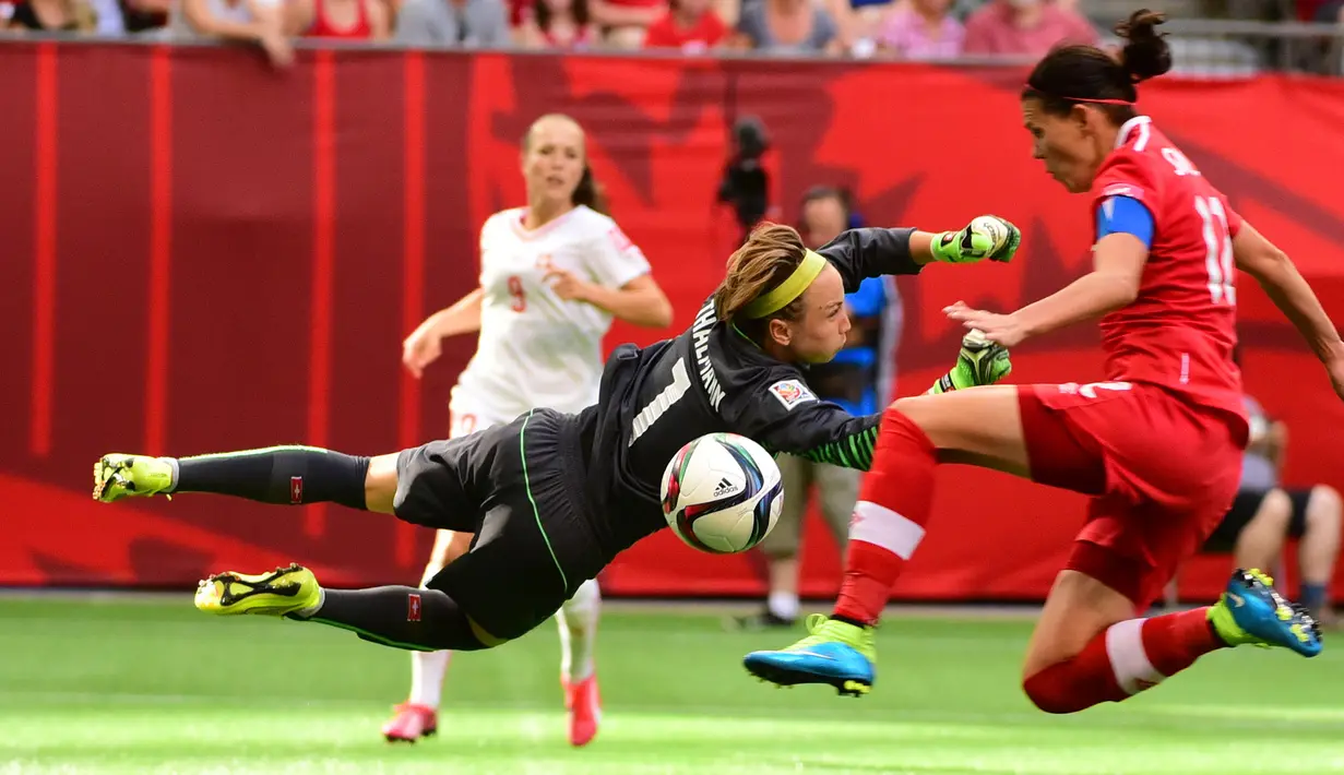 Kiper Swiss, Gaelle Thalmann melompat menghalau bola tendangan penyerang Kanada, Christine Sinclair saat Piala Dunia wanita 2015 di BC Place Stadium, Senin (22/6/2015). Kanada menang 1-0 atas Swiss lewat gol Josee Belanger. (Reuters/Anne Marie Sorvin)