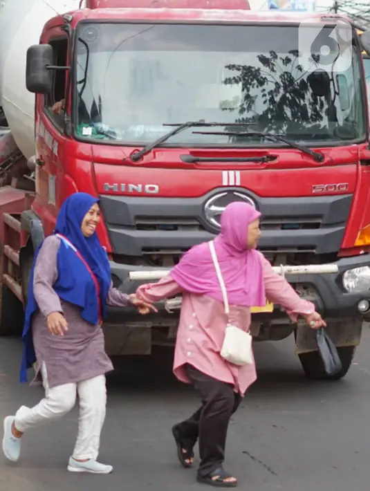 Pejalan kaki menyeberangi jalan di depan Stasiun Lenteng Agung, Jakarta, Senin (4/11/2019). Meski telah tersedia JPO, sebagian pejalan kaki lebih memilih untuk menyeberang sembarangan sehingga mengganggu arus lalu lintas serta berpotensi menimbulkan kecelakaan. (Liputan6.com/Immanuel Antonius)