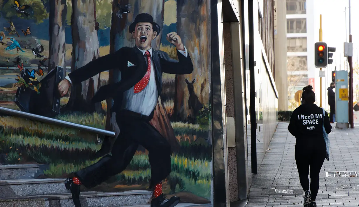 metropolitan Perth. (AFP/Trevor Collens)
Seorang wanita berjalan melewati mural di Perth (29/6/2021). Kota ini mengikuti Sydney dan Darwin melakukan lockdown untuk menahan wabah baru varian Delta yang sangat menular. (AFP/Trevor Collens)