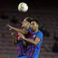 Gelandang Barcelona, Gavi dan Sergio Busquets melompat untuk menyundul saat menjamu Granada pada lanjutan La Liga di Camp Nou, Selasa (21/9/2021) dini hari WIB. Barcelona dipaksa bermain imbang 1-1 oleh tamunya Granada. (AP Photo/Joan Monfort)