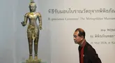 Seorang warga Thailand melihat patung Siwa berdiri dari abad ke-11 saat upacara pemulangan di Museum Nasional di Bangkok, Thailand, Selasa (21/5/2024). (AP Photo/Sakchai Lalit)