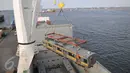 Pekerja memindahkan gerbong KRL dari kapal menggunakan alat berat di Pelabuhan Tanjung Priok, Jakarta, Rabu (6/1). Kedatangan gerbong KRL ini menandai akhir program pengadaan 120 kereta PT KAI Commuter Jabodetabek tahun 2015. (Liputan6.com/Gempur M Surya)