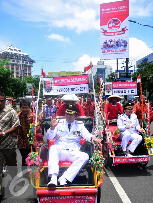 Hendar Prihadi dan Hevearita Gunaryanti menyapa warga saat di arak dengan becak usai pelantikan di Semarang , Rabu (17/2). 17 pasangan kepala daerah diambil sumpah jabatan masing-masing untuk daerah Jawa Tengah. (Liputan6.com/Gholib)