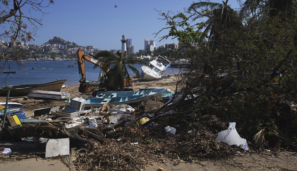 Mobil-mobil dapat kembali melaju di jalan-jalan utama kota melewati reruntuhan dan pohon-pohon palem yang ditebang. (AP Photo/Marco Ugarte)