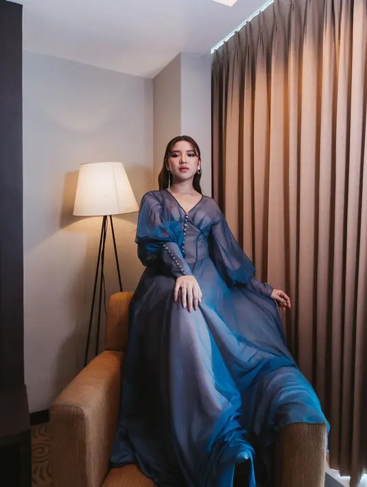 Di sini, Tiara Andini tampil secantik princess dengan long dress berwarna biru navy. Dress ini cantik sekali dengan detail leher berbentuk V, lengan panjang, dan bagian rok yang menjuntai panjang hingga ke lantai. Foto: Instagram.