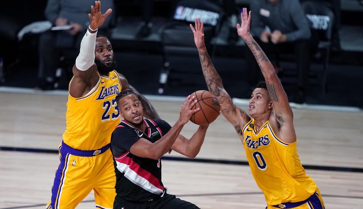 Pebasket Portland Trailblazers, CJ McCollum, berebut bola dengan pebasket LA Lakers pada babak pertama playoff NBA 2020 di AdventHealth Arena, Rabu (19/8/2020). LA Lakers takluk 93-100 atas Portland Trailblazers. (AFP/Ashley Landis-Pool/Getty Images)