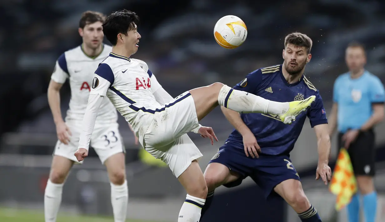 Gelandang Tottenham Hotspur, Son Heung-min menguasai bola di depan striker Dinamo Zagreb, Bruno Petkovic dalam laga leg pertama babak 16 besar Liga Europa 2020/2021 di Tottenham Hotspur Stadium, London, Kamis (11/3/2021). Tottenham menang 2-0 atas Dinamo Zagreb. (AP/Alastair Grant/Pool)