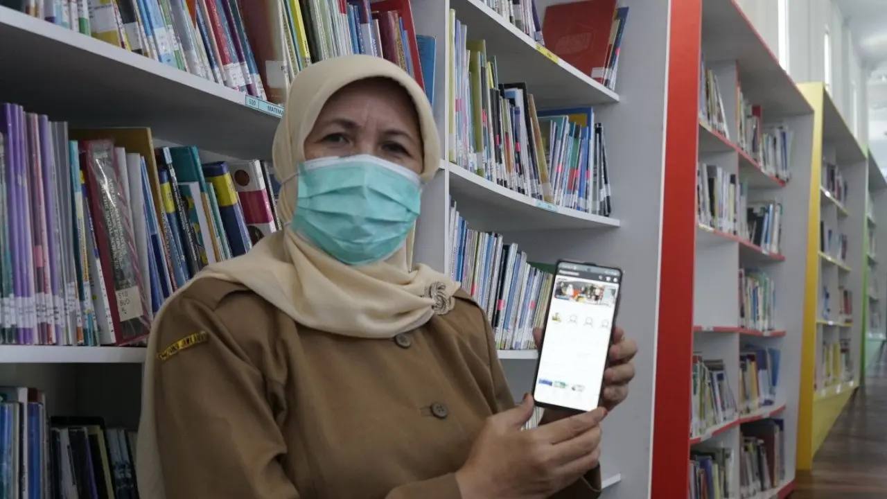 Kepala Dinas Perpustakaan dan Kearsipan Kabupaten Garut, Lisnawati tengah menunjukan penggunaan aplikasi online i-Bagendit bagi masyarakat di masa pandemi.