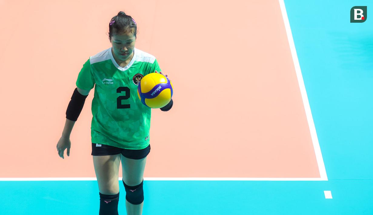 Pemain Timnas Bola Voli Putri Indonesia, Ratri Wulandari bersiap melakukan servis pada laga lanjutan Grup A Bola Voli Putri SEA Games 2023 melawan Myanmar di Olympic Complex Indoor Stadium, Phnom Penh, Kamboja, Kamis (11/5/2023). Ratri berhasil mencetak total 19 poin, dimana sebanyak 13 angkanya ditorehkan melalui situasi bola servis. (Bola.com/Abdul Aziz)