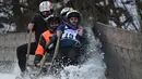 Peserta menabrak pembatas arena saat mengikuti lomba kereta luncur tanduk tradisional di Desa Bavaria, Garmisch-Partenkirchen, Jerman (6/1). Di masa lalu petani gunung menggunakan kereta luncur untuk transportasi barang. (AFP Photo/Christof Stache)