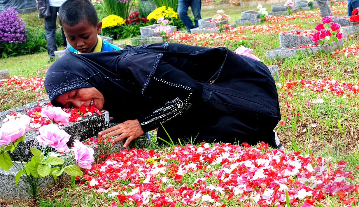 Keluarga korban Tragedi Mei 98 memeluk nisan makam sanak famili mereka yang menjadi korban Tragedi Mei 98 di TPU Pondok Ranggon, Jakarta Timur, Rabu (13/5/2015). (Liputan6.com/Yoppy Renato)