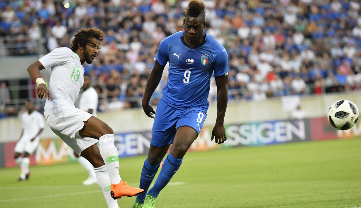 Pemain Arab Saudi, Ysir Alshahrani (kiri) membuang bola saat diadang pemain Italia, Mario Balotelli pada laga persahabatan di Kybunpark Stadium, St. Gallen, Swiss, (28/5/2018). Italia menang 2-1. (Gian Ehrenzeller/Keystone via AP)