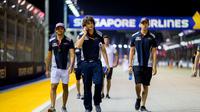 Sean Gelael (kanan) tengah melakukan track walk di Sirkuit Marina Bay bersama Carlos Sainz Jr (kiri) dan tim Toro Rosso jelang sesi latihan bebas pertama F1 GP Singapura. (Scuderia Toro Rosso)