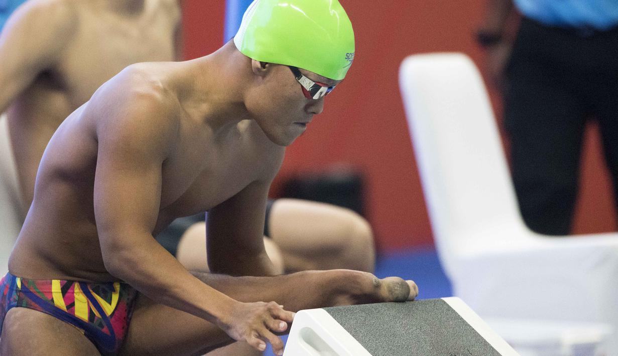 Aksi Aris perenang Indonesia yang berhasil meraih medali perak di nomor 100 meter gaya dada klasifikasi SB7 pada Asian Para Games 2018, Gelora Bung Karno Jakarta, Senin (8/10/2018).  (Bola.com/Peksi Cahyo)