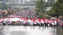 Ribuan massa berkumpul memeriahkan aksi damai 'Kita Indonesia' di Bundaran HI, Jakarta, Minggu (4/12). Sebuah bendera Merah Putih raksasa dibawa berkeliling Bundaran HI oleh sejumlah warga sambil meneriakkan 'Kita Indonesia'. (Liputan6.com/Fery Pradolo)