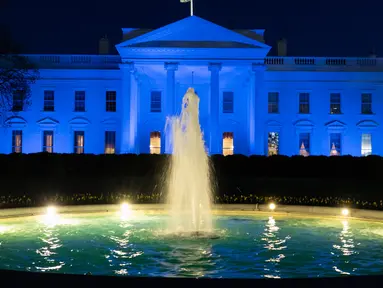 Gedung Putih diterangi dengan cahaya warna biru untuk menarik perhatian pada World Autism Awareness Day atau Hari Peduli Autisme Sedunia di Washington, Kamis (2/4/2020). Hari Peduli Autisme Sedunia jatuh setiap 2 April semenjak ditetapkan melalui sebuah resolusi PBB di tahun 2007. (AP/Alex Brandon)