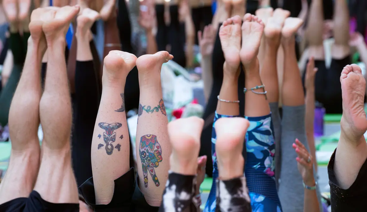 Peserta berpartisipasi dalam yoga outdoor di kawasan Times Square, New York saat Summer Solstice atau hari dengan siang terpanjang di musim panas, Kamis (21/6). Acara itu menandai Hari Yoga Internasional yang jatuh pada 21 Juni. (AP Photo/Mary Altaffer)