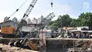 Petugas melakukan evakuasi crane jatuh di kawasan Kemayoran, Jakarta, Kamis (6/12). Crane yang digunakan untuk pembangunan turap Kali Sentiong tersebut jatuh hingga menimpa rumah warga dan menyebabkan tiga orang luka-luka. (Merdeka.com/Iqbal S. Nugroho)