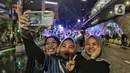 <p>Warga berswafoto saat perayaan malam pergantian tahun di kawasan Jalan MH Thamrin, Jakarta Minggu (31/12/2023). (Liputan6.com/Angga Yuniar)</p>