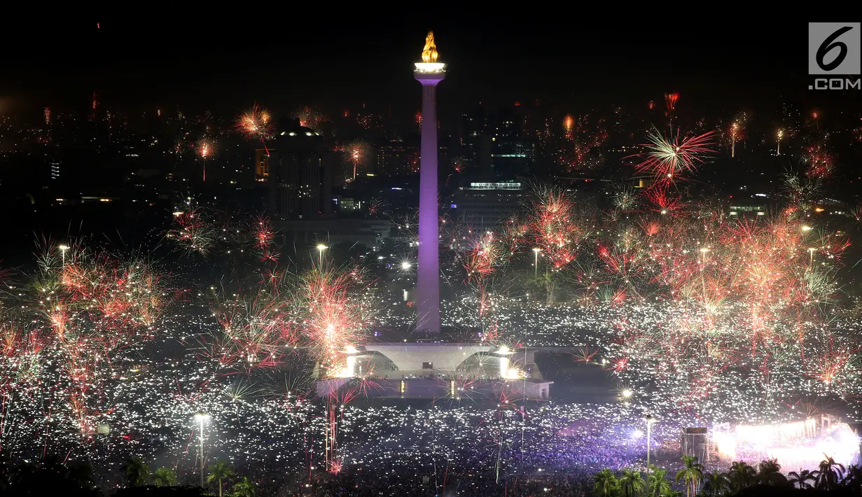 Kembang api menghiasi malam pergantian tahun baru 2018 di kawasan silang Monumen Nasional (Monas), Jakarta, Senin (1/1/2018). Monas menjadi salah satu lokasi pilihan Warga Jakarta untuk merayakan malam pergantian tahun. (Liputan6.com/Johan Tallo)