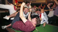 Pesta suporter Inggris pecah setelah Harry Kane mencetak gol kemenangan The Three Lions pada laga grup E Piala Dunia 2018 di Millennium Square, Leeds, Inggris, (18/6/2018). Inggris menang 2-1. (Nigel French/PA via AP)