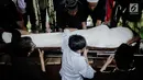 Keluarga dan kerabat  memasukkan jenazah aktor senior Deddy Sutomo ke liang lahat saat pemakaman di TPU Tanah Kusir, Jakarta, Rabu (18/4). Deddy Sutomo meninggal dunia pada usia 77 tahun. (Liputan6.com/Faizal Fanani)