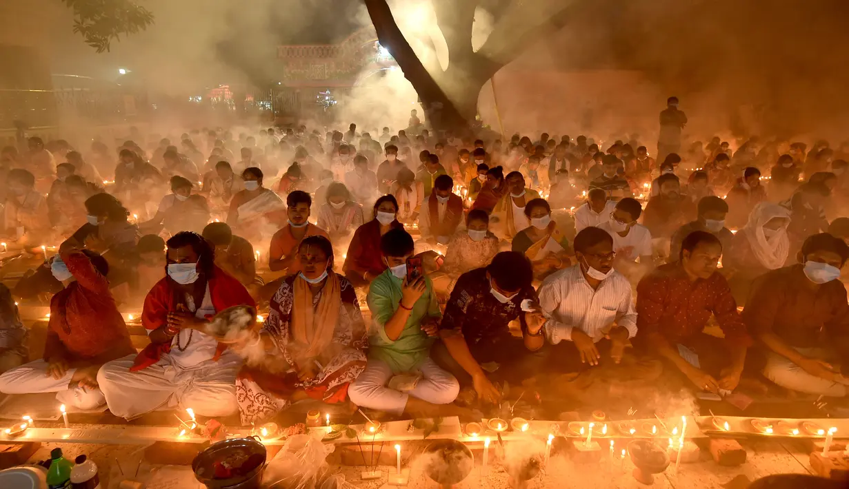 Umat Hindu duduk berdoa sambil membakar dupa dan lampu minyak selama festival puasa keagamaan Rakher Upobash di sebuah kuil di Distrik Narayanganj, pinggiran Dhaka, ibu kota Bangladesh, pada 7 November 2020. (Xinhua)