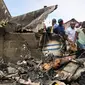 Tim penyelamat berkumpul setelah sebuah pesawat jatuh di kawasan padat penduduk, Goma, Republik Demokratik Kongo, Minggu (24/11/2019). Pesawat tersebut sedianya menuju ke Beni, 350 kilometer di utara Goma. (AP Photo/Justin Kabumba)