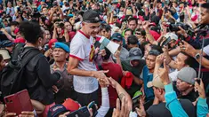 Bakal calon presiden dari PDIP yang juga Gubernur Jawa Tengah Ganjar Pranowo (tengah) menyapa pendukungnya saat berolahraga di Kompleks Stadion Utama Gelora Bung Karno (SUGBK), Jakarta, Minggu (30/4/2023). (Liputan6.com/Faizal Fanani)