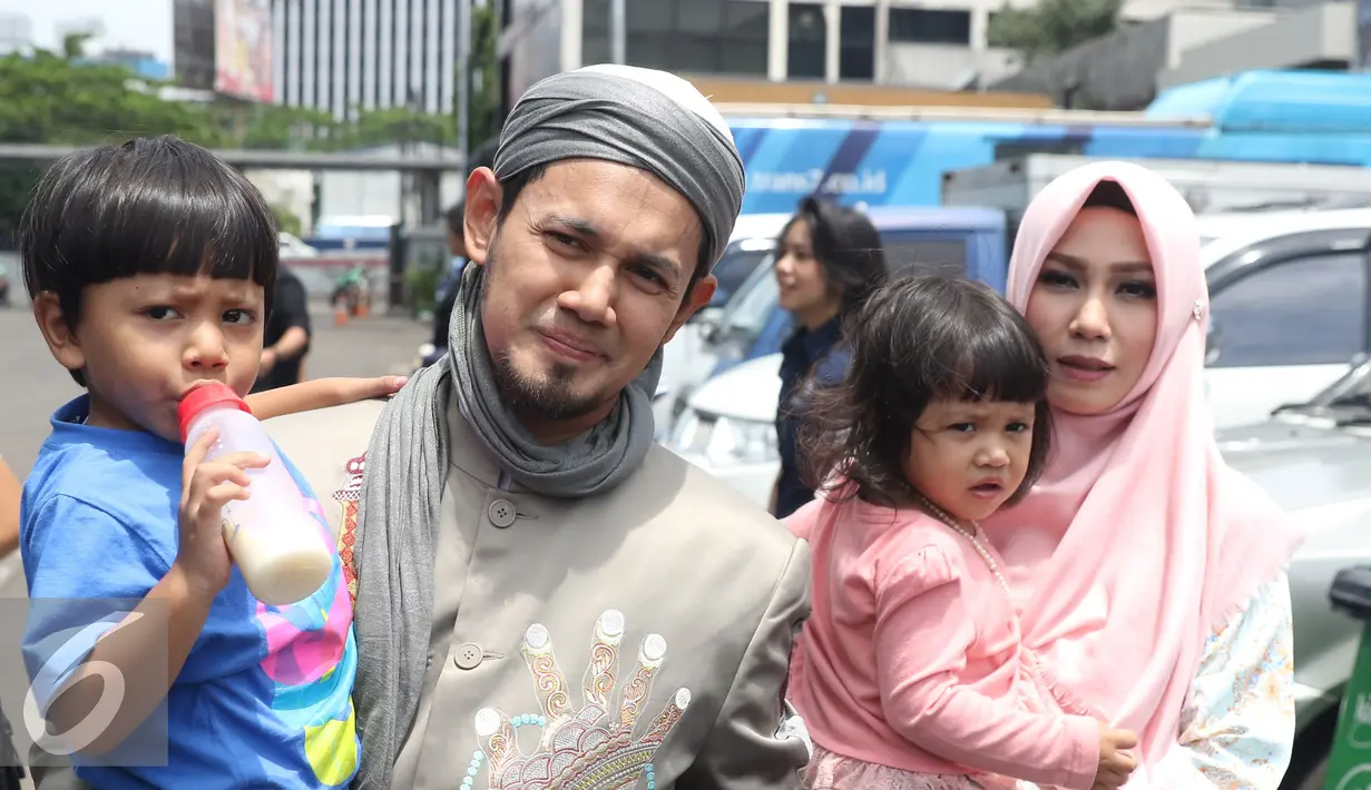 Ustadz Guntur Bumi (UGB), Puput Melati dan kedua anaknya usai mengisi sebuah acara di kawasan Tendean, Jakarta, Rabu (16/11). UGB dan Puput mengaku sudah kembali rujuk pasca cerai pada Januari 2014 silam. (Liputan6.com/Herman Zakharia)