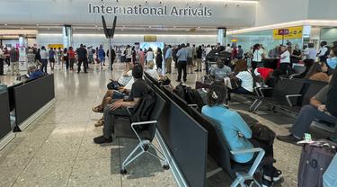 Wisatawan menunggu jadwal penerbangan mereka di bandara Heathrow, di London,  Rabu (13/7/2022). Bandara Heathrow membatasi jumlah penumpang yang berangkat hingga 100.000 penumpang per hari pada periode musim panas ini, dari 12 Juli hingga 11 September. (AP Photo/Alberto Pezzali)