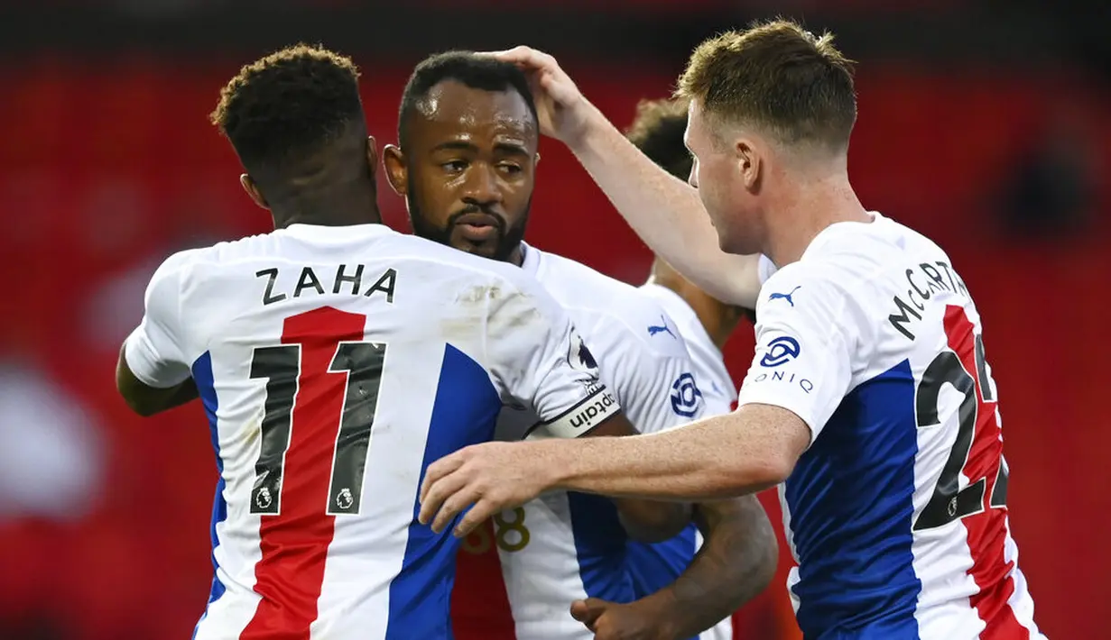 Pemain Crystal Palace, Wilfried Zaha, melakukan selebrasi bersama Jordan Ayew usai mencetak gol ke gawang Manchester United pada laga Premier League di Stadion Old Trafford, Sabtu (19/9/2020). Setan Merah takluk dengan skor 1-3.  (Shaun Botterill/Pool via AP)