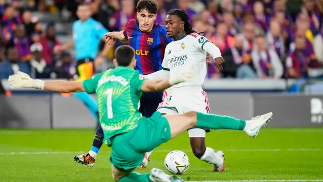 Pemain Real Madrid Eduardo Camavinga (kanan) coba dihentikan oleh kiper Barcelona Joan Garcia