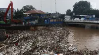 Bus Transjakarta melintasi tumpukan sampah di Pintu Air Manggarai, Jakarta, Rabu (24/4). Tingginya curah hujan di Bogor membuat sampah yang berasal kebanyakan dari sampah rumah tangga ini terbawa arus sungai menumpuk di Pintu Air Manggarai. (Liputan6.com/Johan Tallo)