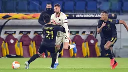 Penyerang AS Roma, Borja Mayoral berebut bola dengan bek Ajax Amsterdam, Lisandro Martinez pada leg kedua perempat final Liga Europa di Olimpico, Jumat (16/4/2021) dini hari WIB. AS Roma melaju ke semifinal Liga Europa musim ini setelah bermain imbang 1-1 lawan Ajax. (Fabio Rossi/LaPresse via AP)