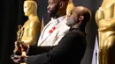 Sutradara Barry Jenkins dan penulis Moonlight, Tarell Alvin McCraney berpose sambil memegang piala Oscar di Hollywood, California, AS (26/2). (AFP/Robyn Beck)