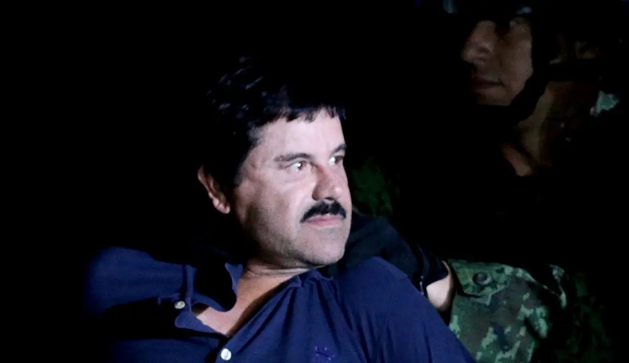 Ekspresi bos narkoba Joaquin "El Chapo" Guzman saat dikawal ketat oleh tentara di kantor Kejaksaan Agung, Meksiko (8/1/2016). Joaquin "El Chapo" Guzman melarikan diri dari penjara melalui terowongan yang ia buat pada 11 Juli 2015. (REUTERS/Henry Romero)