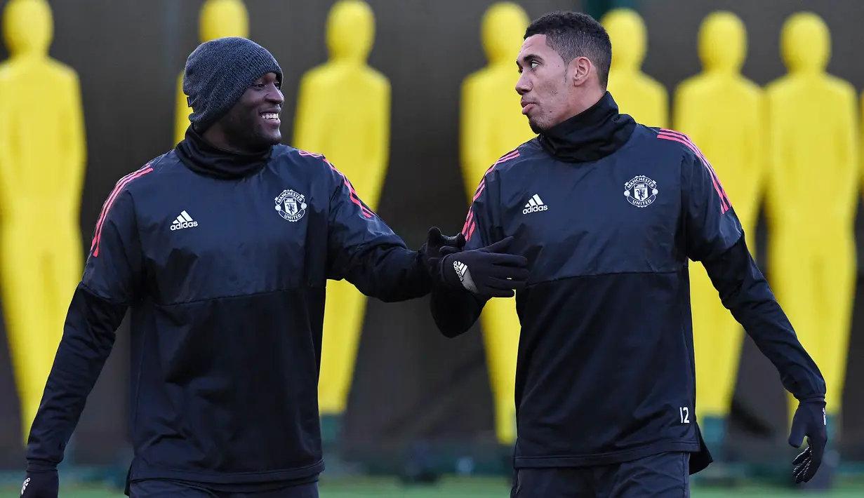 Pemain Manchester United, Romelu Lukaku berbincang dengan Chris Smalling saat mengikiuti sesi latihan jelang laga Liga Champions di Manchester, Senin (4/12/2017). Manchester United akan berhadapan dengan CSKA Moscow. (AFP/Paul Ellis)