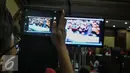 Pengunjung sidang mengabadikan rekaman CCTV dalam persidangan saksi kasus pembunuhan Wayan Mirna Salihin di PN Jakarta Pusat, Rabu (13/7). Sidang menampilkan video CCTV yang berisi rekaman kejadian di Kafe Olivier. (Liputan6.com/Faizal Fanani)