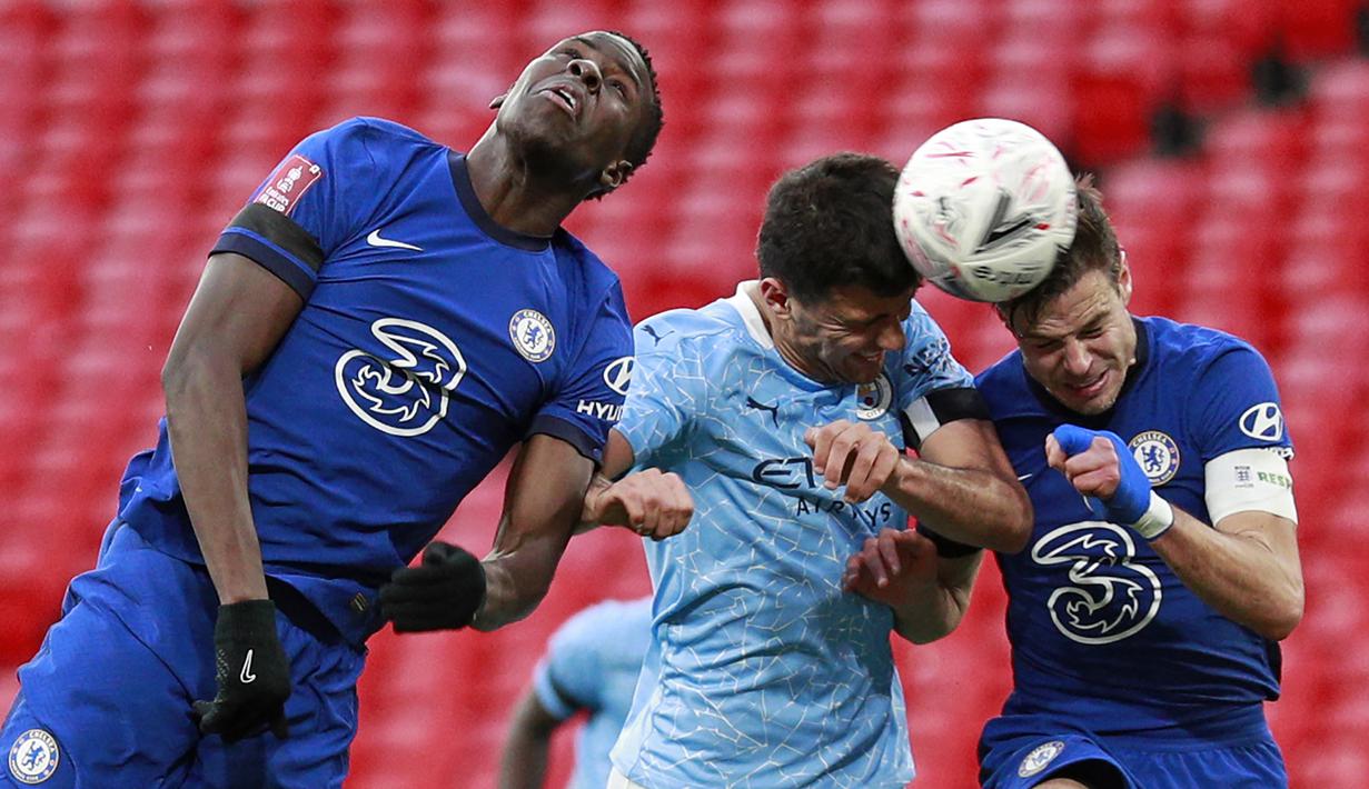 Gelandang Manchester City, Rodrigo (tengah) menyundul bola di antara dua pemain Chelsea, Kurt Zouma (kiri) dan Cesar Azpilicueta dalam laga semifinal Piala FA 2020/2021 di Wembley Stadium, London, Sabtu (17/4/2021). Manchester City kalah 0-1 dari Chelsea. (AFP/Ian Walton/Pool)