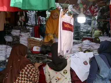 Aktivitas pedagang melayani pembeli seragam sekolah di Pasar Jatinegara, Jakarta , Selasa (2/7/2024). (Liputan6.com/Herman Zakharia)